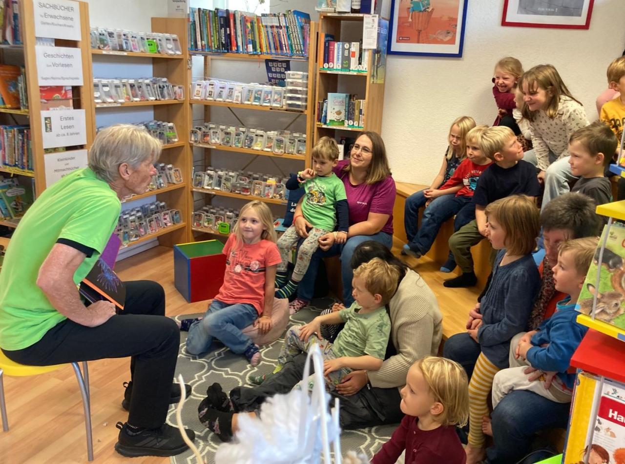 Mann liest Kindern etwas vor