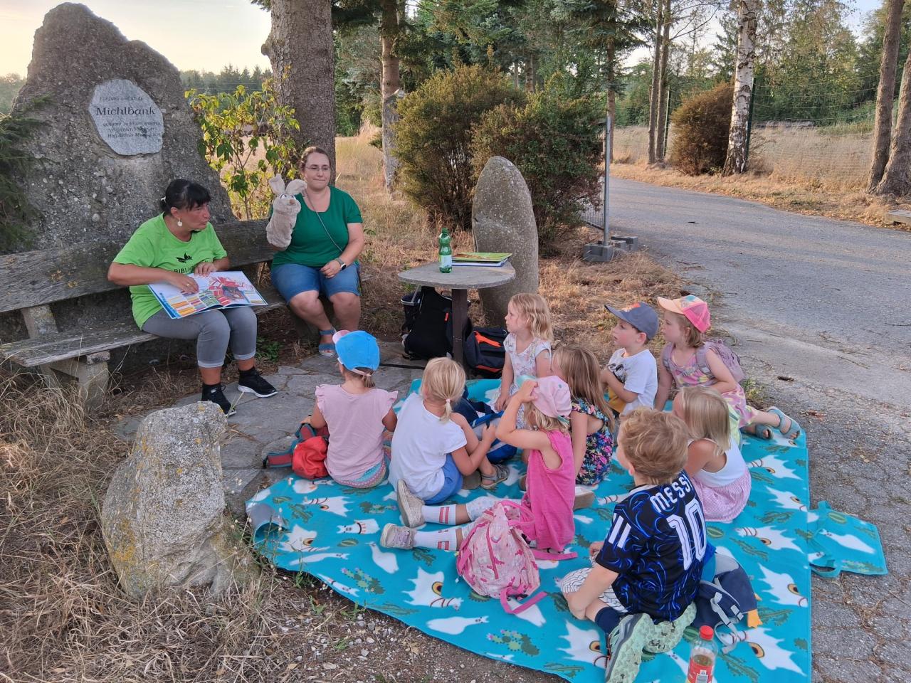 Kinder auf Picknickdecke lauschen einer Geschichte