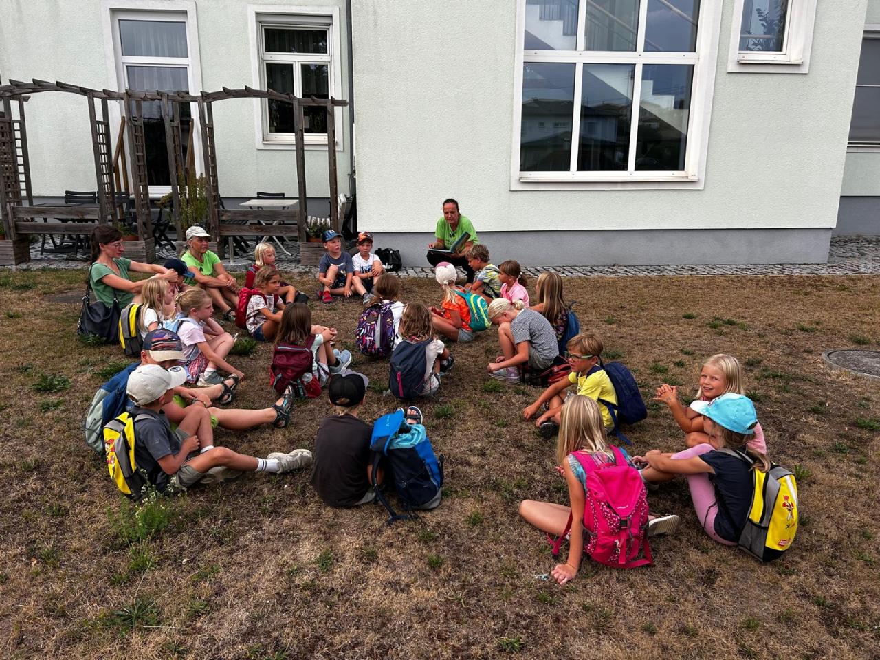 Kinder sitzen auf einer Wiese