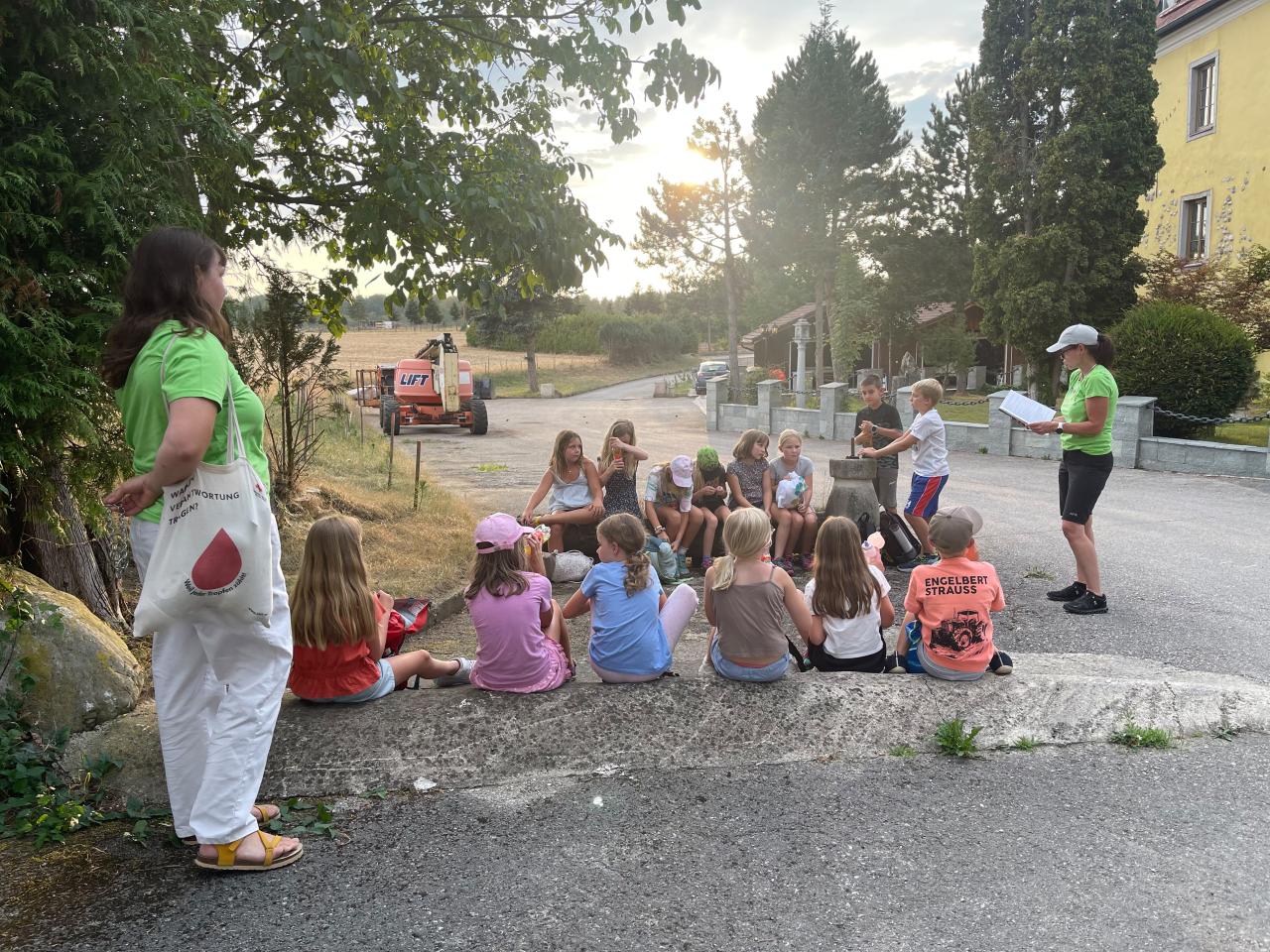 Kinder sitzen am Boden und Frau liest