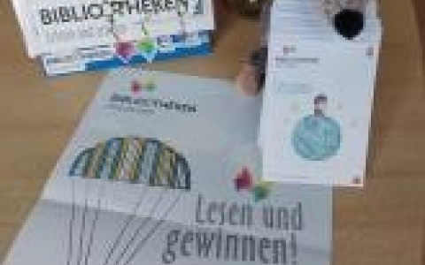 Plakat mit Lesepässen und Stoffmaus