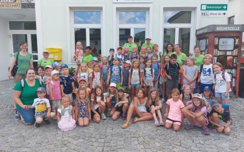 Gruppenbild von 46 Kindern und 10 Erwachsenen vor der Bücherei außen